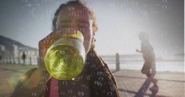 Gezinti güvertesinde su içen melez bir kadının üzerine kabarcıklar. sağlık ve zindelik kavramı dijital olarak oluşturulmuş video.