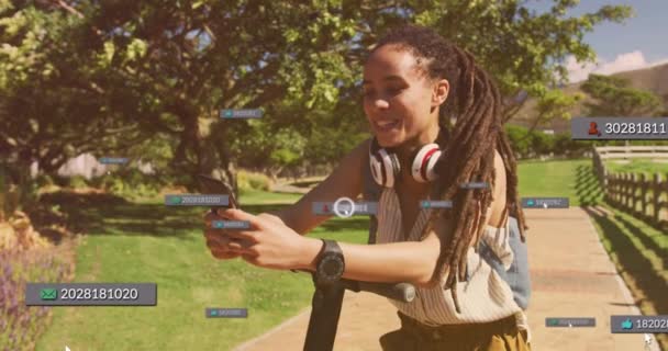 Animação Ícones Mídia Sobre Mulher Biracial Usando Smartphone Com Scooter — Vídeo de Stock