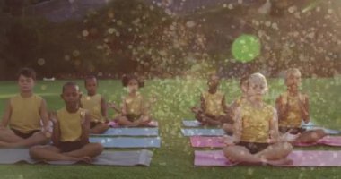 Yoga ve meditasyon yapan çeşitli çocuklar üzerinde ışık noktaları oluşturuluyor. dünya meditasyon günü ve dijital olarak üretilen video konsepti.
