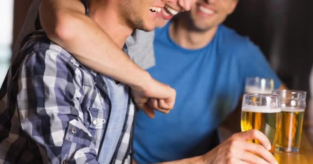 Glückliche Kaukasische Männliche Sportfans Umarmen Und Trinken Der Bar Lachen — Stockvideo