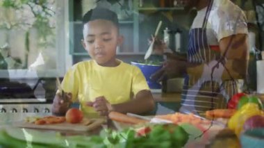 Mutlu Afro-Amerikan baba ve oğlunun birlikte yemek pişirmesi üzerine yaprakların animasyonu. aile, birliktelik, kaliteli zaman konsepti dijital olarak oluşturulmuş video.