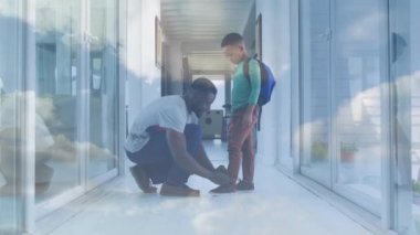 Mutlu Afro-Amerikan babasının oğluna ayakkabı bağlaması üzerine ışıkların animasyonu. aile, birliktelik, kaliteli zaman konsepti dijital olarak oluşturulmuş video.