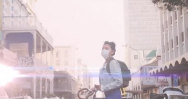 Yüz maskeli, bisikletli, melez bir kadının üzerindeki ışık lekelerinin canlandırılması. Ulusal bisiklet iş günü için ve covid 19 salgın konsepti dijital olarak oluşturulan video sırasında kutlamak için.