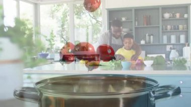 Mutlu Afro-Amerikan baba ve oğlunun birlikte yemek pişirdiği domateslerin animasyonu. aile, birliktelik, kaliteli zaman konsepti dijital olarak oluşturulmuş video.