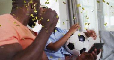 Mutlu Afro-Amerikan baba ve oğlunun el çırpışları üzerine düşen konfeti animasyonu. aile, birliktelik, kaliteli zaman konsepti dijital olarak oluşturulmuş video.