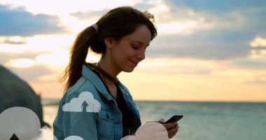 Sahilde akıllı telefon kullanan melez bir kadının göbeğindeki bulutların canlandırması. küresel bağlantılar, sosyal medya, teknoloji ve dijital arayüz konsepti dijital olarak oluşturulmuş video.