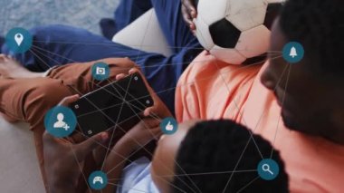 Afrika kökenli Amerikalı baba ve oğul arasında kopyalanmış akıllı telefonları kullanarak yapılan bağlantıların animasyonu. aile, birliktelik, teknoloji konseptiyle dijital olarak oluşturulmuş video ile zaman geçirme.
