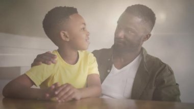 Mutlu Afro-Amerikan baba ve oğlunun konuşmaları üzerine ışık animasyonu. aile, birliktelik, kaliteli zaman konsepti dijital olarak oluşturulmuş video.