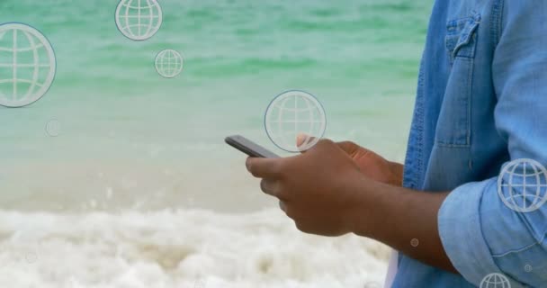 Animazione Globi Sopra Sezione Centrale Dell Uomo Afroamericano Utilizzando Smartphone — Video Stock