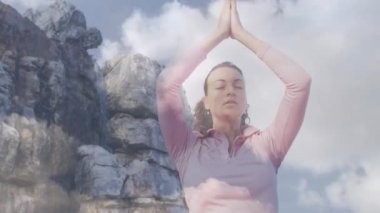 Kafkasyalı bir kadının yoga ve meditasyon yapması üzerine bulutların animasyonu. dünya meditasyon günü ve dijital olarak üretilen video konsepti.