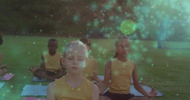 Yoga ve meditasyon yapan çeşitli çocuklar üzerinde ışık noktaları oluşturuluyor. dünya meditasyon günü ve dijital olarak üretilen video konsepti.