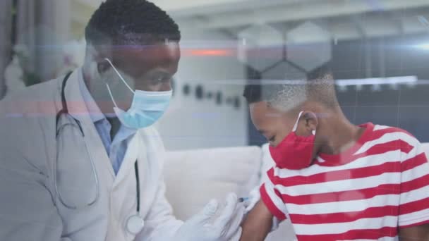 Animacja Sześciokątów Nad Afrykańskim Amerykańskim Lekarzem Masce Twarzy Szczepiącym Chłopca — Wideo stockowe