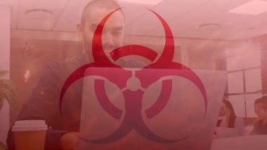 Çift ırklı iş adamının ofisindeki dizüstü bilgisayarla biyolojik tehlike sembolünün animasyonu. küresel iş, finans, bağlantılar ve dijital arayüz konsepti dijital olarak oluşturulmuş video.