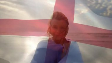 Sahildeki mutlu Kafkasyalı kadın yerine İngiltere bayrağının animasyonu. yaşlılar yaşam tarzı, emeklilik ve tatil konsepti dijital olarak oluşturulmuş video.