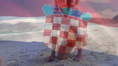 Sahildeki beyaz aile üzerinde Hırvat bayrağının canlandırılması. Vatanseverlik ve kutlama konsepti dijital olarak oluşturulmuş video.