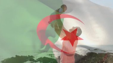Kumsalda bebeği olan beyaz bir adam üzerinde Cezayir bayrağının animasyonu. Vatanseverlik ve kutlama konsepti dijital olarak oluşturulmuş video.