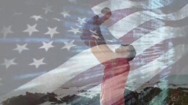 Amerika bayrağının animasyonu, kumsalda bebeği olan beyaz bir adam üzerinde. Vatanseverlik ve kutlama konsepti dijital olarak oluşturulmuş video.