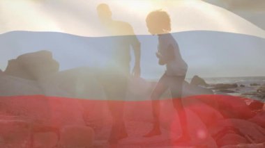 Sahildeki Afro-Amerikan çift üzerinde Rus bayrağının animasyonu. Vatanseverlik ve kutlama konsepti dijital olarak oluşturulmuş video.