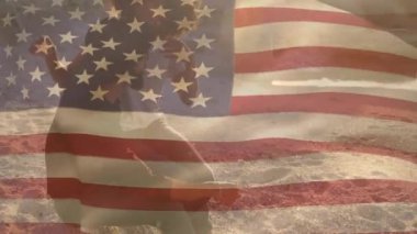 Sahildeki Afro-Amerikan çifti üzerine Amerikan bayrağının animasyonu. Vatanseverlik ve kutlama konsepti dijital olarak oluşturulmuş video.