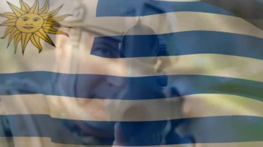 Uruguay bayrağının Kafkasyalı silahlı erkek asker üzerinde canlandırılması. Ordu, kamu savunması ve vatanseverlik kavramı dijital olarak oluşturulmuş video.