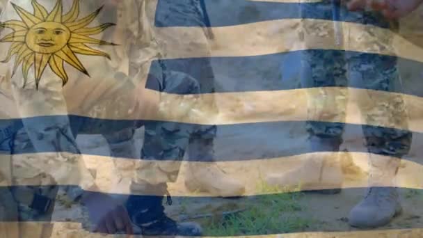 Κινούμενη Σημαία Του Uruguay Πάνω Από Διάφορα Αρσενικά Στρατιώτες Όπλα — Αρχείο Βίντεο