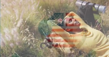 Dağlarda yatan melez bir kadının üzerine Amerikan bayrağının animasyonu. Vatanseverlik ve kutlama konsepti dijital olarak oluşturulmuş video.