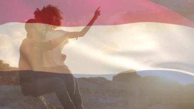 Sahildeki Afro-Amerikan çift üzerinde Hollanda bayrağının animasyonu. Vatanseverlik ve kutlama konsepti dijital olarak oluşturulmuş video.