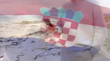 Kıdemli beyaz adamın sahilde akıllı telefon kullanması üzerine Hırvat bayrağının animasyonu. yaşlılar yaşam tarzı, emeklilik ve tatil konsepti dijital olarak oluşturulmuş video.