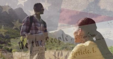 Dağlarda yürüyüş yapan gülümseyen çift üzerine Amerikan bayrağı animasyonu. Vatanseverlik ve kutlama konsepti dijital olarak oluşturulmuş video.