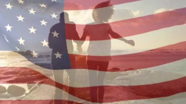 Sahildeki Afro-Amerikan çifti üzerine Amerikan bayrağının animasyonu. Vatanseverlik ve kutlama konsepti dijital olarak oluşturulmuş video.