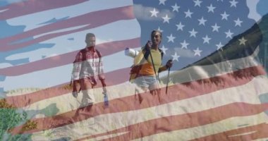 Dağlarda yürüyüş yapan gülümseyen çift üzerine Amerikan bayrağı animasyonu. Vatanseverlik ve kutlama konsepti dijital olarak oluşturulmuş video.