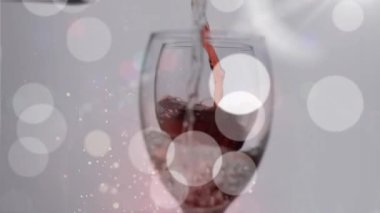 Kırmızı şarabın arka planda ışıklarla bardağa döküldüğü animasyon. şarap işi, tatma ve kutlama konsepti dijital olarak oluşturulmuş video.