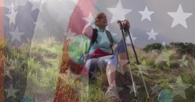 Dağlarda oturan kıdemli, beyaz bir kadının gülümsemesi üzerine Amerikan bayrağının animasyonu. Vatanseverlik ve kutlama konsepti dijital olarak oluşturulmuş video.