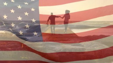 Sahildeki Afro-Amerikan çifti üzerine Amerikan bayrağının animasyonu. Vatanseverlik ve kutlama konsepti dijital olarak oluşturulmuş video.