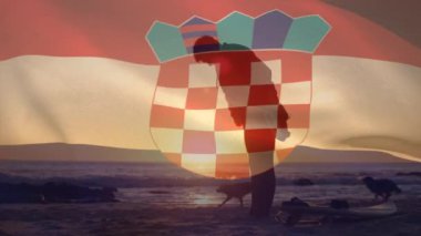 Kumsalda köpekli beyaz bir adam üzerinde Hırvat bayrağı animajı. Vatanseverlik ve kutlama konsepti dijital olarak oluşturulmuş video.