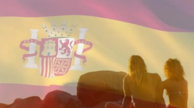 Sahildeki çeşitli arkadaş grupları üzerinde İspanya bayrağının animasyonu. Vatanseverlik ve kutlama konsepti dijital olarak oluşturulmuş video.