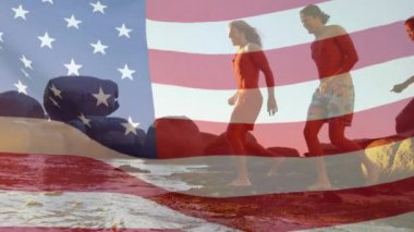 Sahildeki çeşitli arkadaş grupları üzerine Amerika bayrağının animasyonu. Vatanseverlik ve kutlama konsepti dijital olarak oluşturulmuş video.
