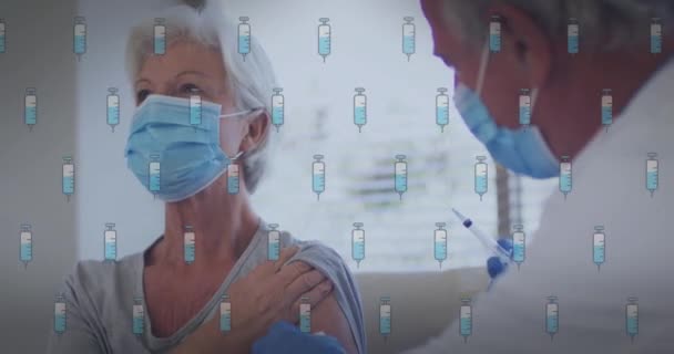 ワクチンのアイコンを介して患者と白人男性医師のアニメーション 世界中の医療 デジタルインターフェースの概念がデジタルで生成されたビデオ — ストック動画