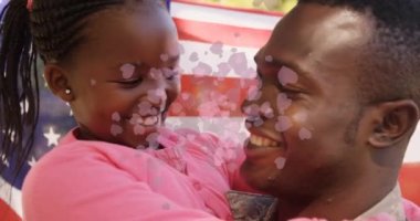 Kalplerin ve Amerikan bayrağının animasyonu mutlu Afrikalı Amerikalı baba ve kızı üzerinde. Uluslararası Aileler Günü ve dijital olarak üretilen video konsepti.