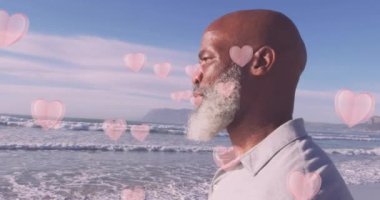 Sahildeki yaşlı Afro-Amerikan adam yerine kupa animasyonu. Sosyal medya ve iletişim arayüzü kavramı dijital olarak oluşturulmuş video.