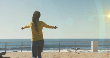 Avluda kolları açık bir şekilde duran Afrikalı Amerikalı bir kadının dikiz aynasına karşı bir ışık lekesi. spor ve spor konsepti