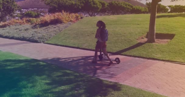 Giovane Donna Afroamericana Con Scooter Elettrico Che Cammina Nel Parco — Video Stock