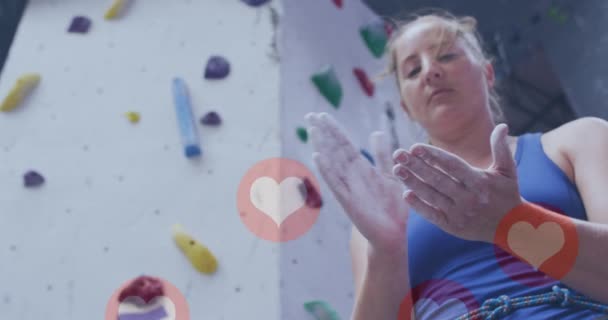 在体育馆里 许多心脏图标飘浮在白人适合的女人的手上 她用粉笔在手上 健身和技术概念 — 图库视频影像
