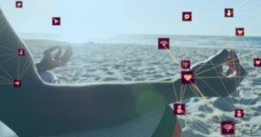 Sahilde meditasyon yapan birinin orta kısmında dönen dijital ikon küreleri. sağlıklı yaşam ve teknoloji kavramı