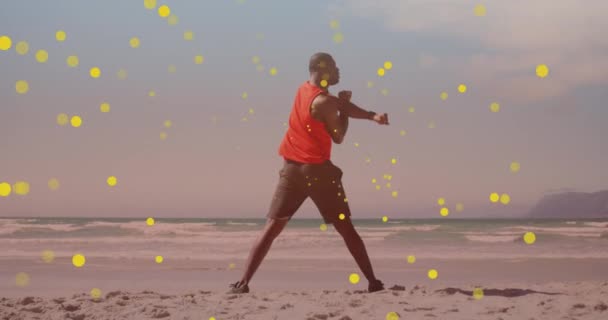 Manchas Amarelas Flutuando Contra Homem Apto Afro Americano Realizando Exercícios — Vídeo de Stock