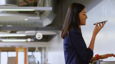 Akıllı telefondan konuşan iki ırklı iş kadınının ikonlarıyla olan bağlantıların animasyonu. küresel iş ve dijital arayüz kavramı dijital olarak oluşturulmuş video.