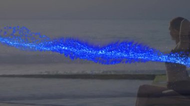 Plajdaki beyaz kadın üzerinde mavi lekelerin canlandırılması. küresel iş ve dijital arayüz kavramı dijital olarak oluşturulmuş video.