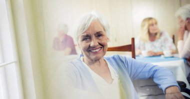 Huzurevinde gülümseyen Kafkasyalı yaşlı kadına karşı fotokopi alanı ile bulanık etki. huzurevi ve yaşam konsepti