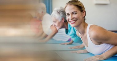 Kadın yoga eğitmeni ve yoga yapan bir grup yaşlı insana karşı fotokopi alanı ile bulanık etki. yoga, meditasyon ve huzurevi kavramı