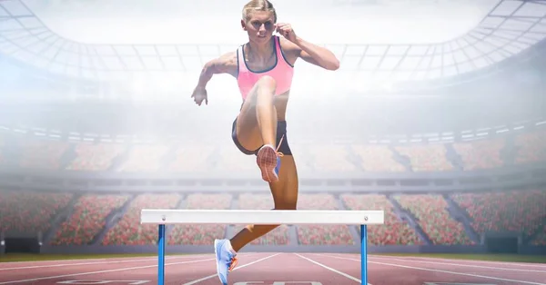 Composite Image Caucasian Female Athlete Jumping Hurdles Sports Stadium Sports — Zdjęcie stockowe